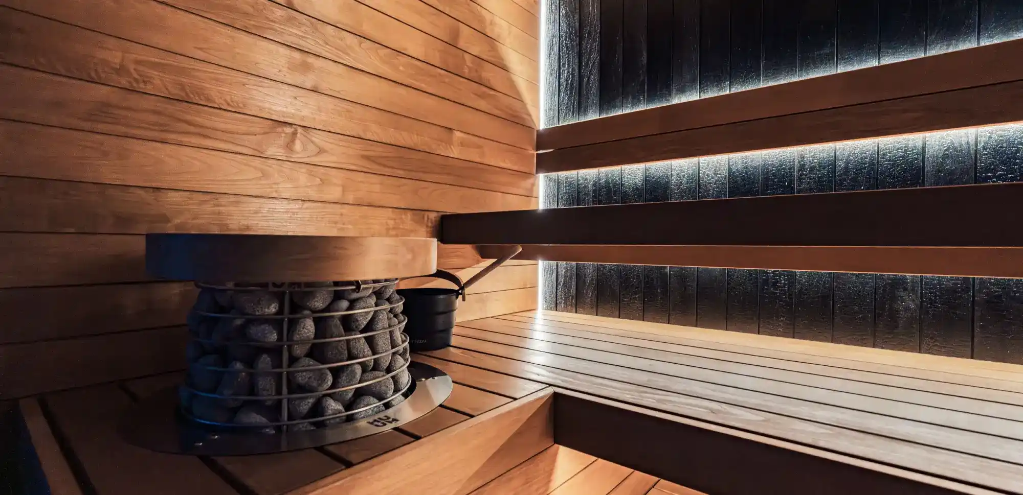 Sauna heater stacked with rocks inside the cedar sauna at Sauna Club Co's Wheat Ridge location